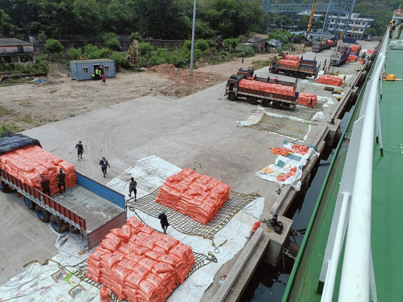 Stacks of bagged cargo on the quay beside a vessel