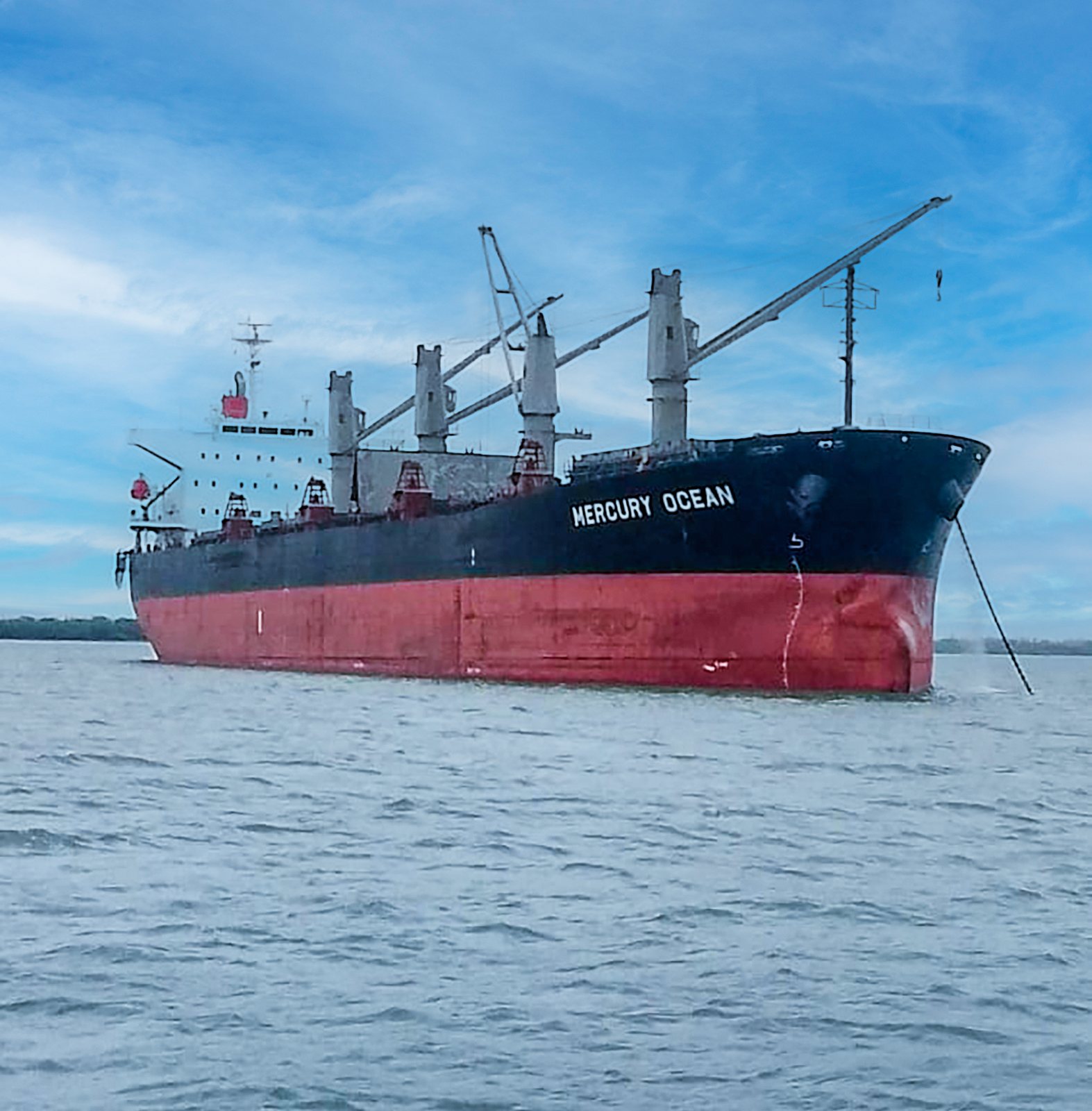 Geared bulk carrier at anchorage awaiting berth